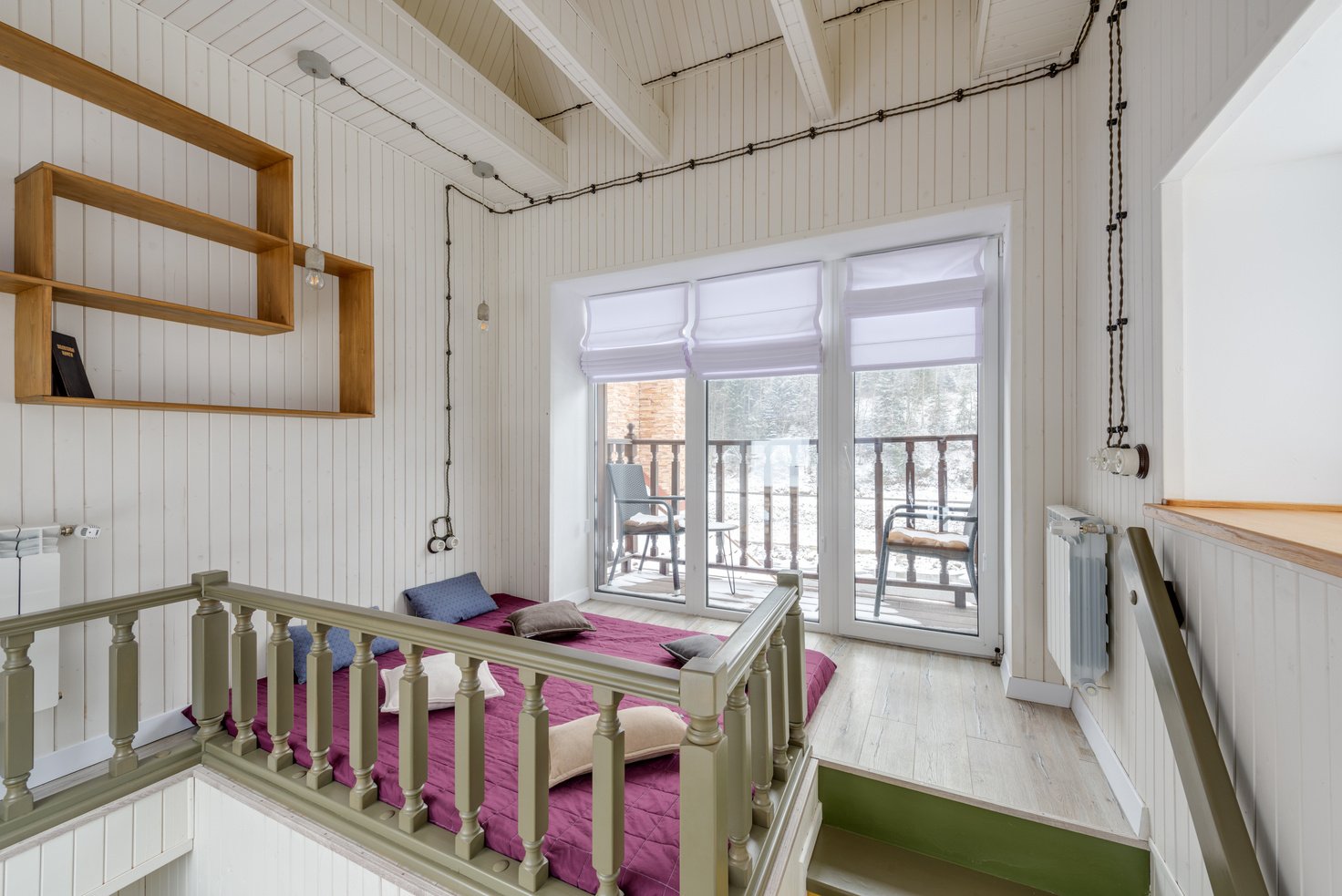 A Purple Bed on a Loft Adjacent to a Balcony 